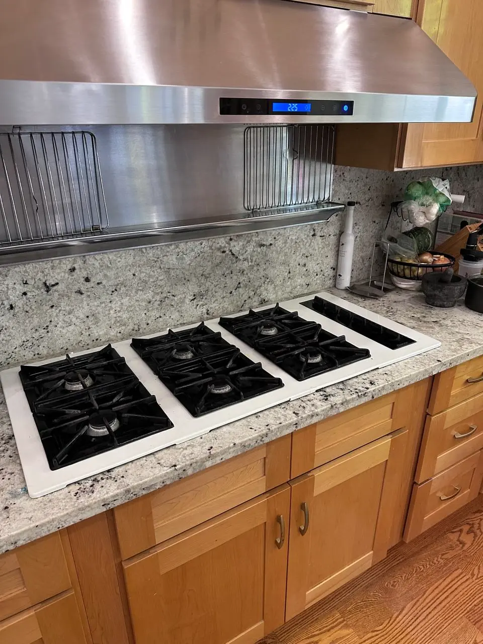 Gas cooktop being fitted into a granite worktop — repaired by Marian Appliance Repair