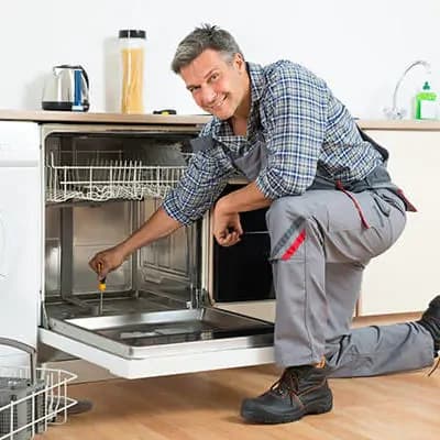 Technician repairing a built-in dishwasher