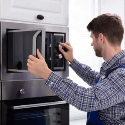Technician working on a built-in microwave