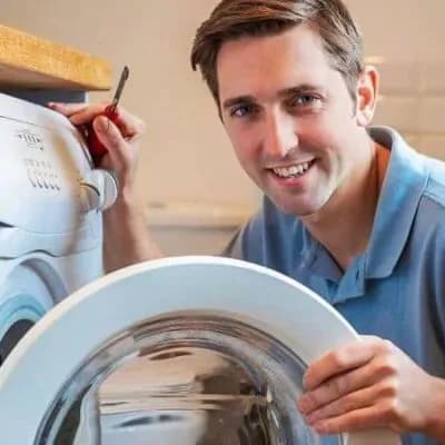 Technician repairing a front-loading washing machine